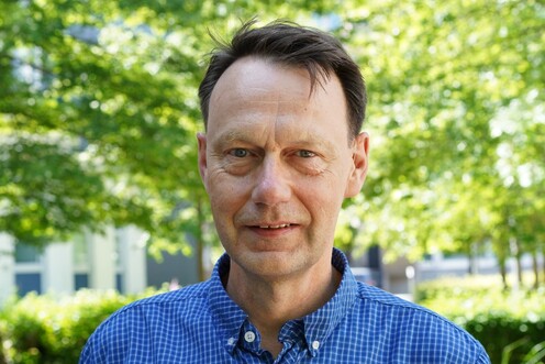 Das Bild zeigt den Techblog-Autor Andreas Nacke in einem blauen Hemd vor einem Baum auf dem OTTO-Campus