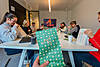 Get together Personen am Tisch schauen in ihre Weihnachtstüten Get together Personen am Tisch schauen in ihre Weihnachtstüten
