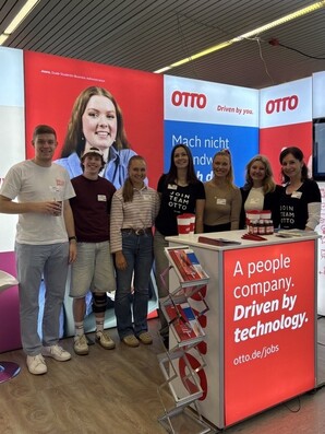 Messestand von OTTO auf der Berufsorientierungsmesse vocatium. Mehrere Teammitglieder stehen vor dem rot-weiß gestalteten Messestand mit Informationsmaterialien zu Ausbildungs- und Studienangeboten bei OTTO.