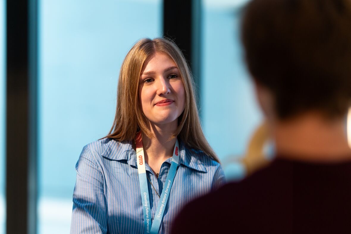Azubi im Bereich E-Commerce Management befindet sich auf den Starter Days und hört aufmerksam zu mit verschränkten Armen.