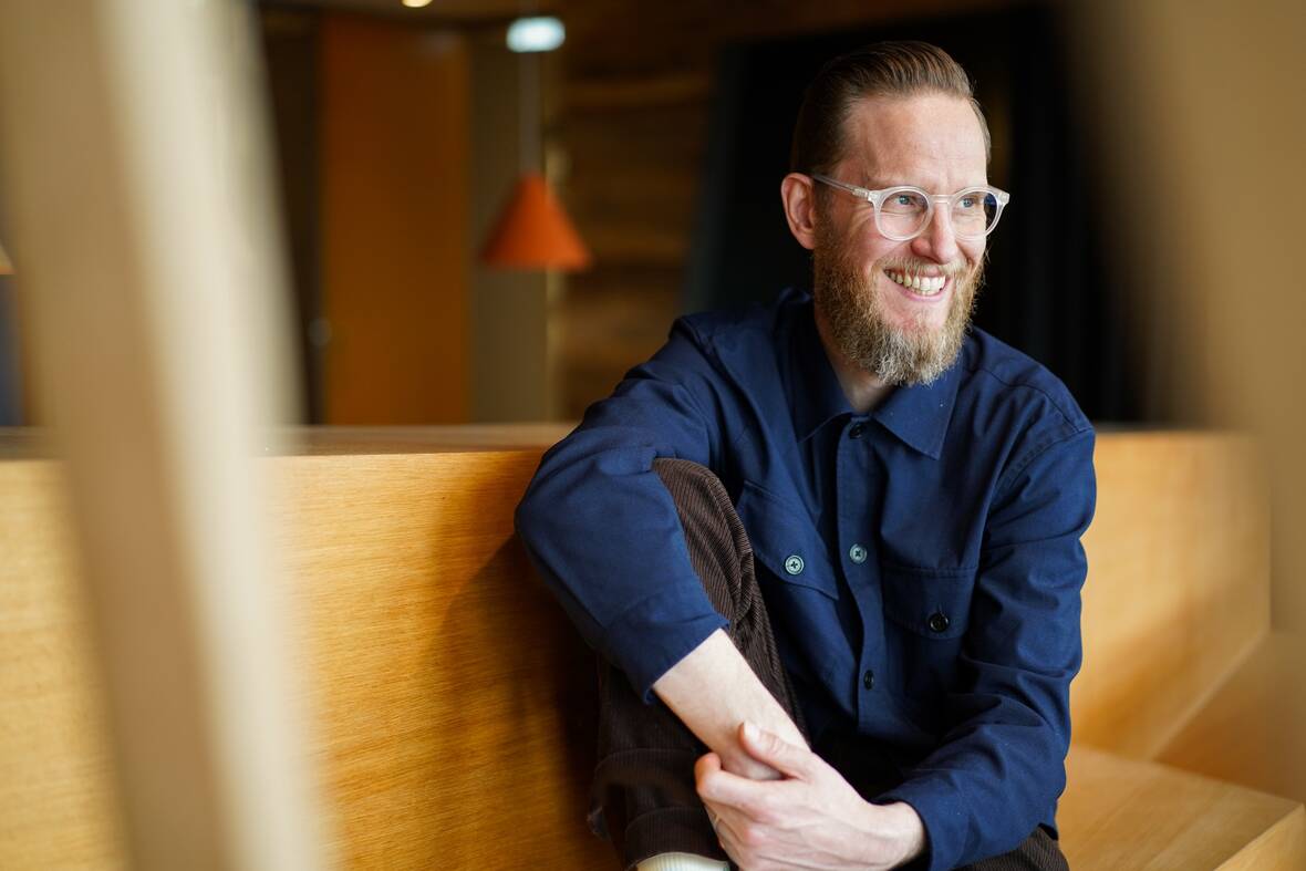 Unser UX-Designer sitzt lässig in lockerer Haltung und guckt zur Seite