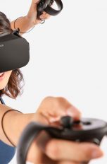 Eine Frau mit einer Oculus Rift und zwei Touch-Controllern in den Händen.