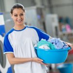 Frau mit Wäschekorb und frisch gewaschener Wäsche