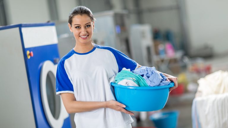 Frau mit Wäschekorb und frisch gewaschener Wäsche