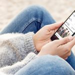 Nutzerin h&auml;lt Smartphone mit aktivierter Cortana-App in der Hand