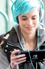 Mädchen spielt mit Nintendo Switch im Bus