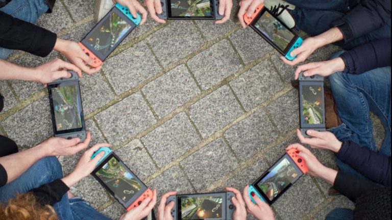 Gruppe von acht Leuten mit jeweils eigener Switch im Handheld-Modus
