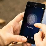 Frau bedient Smartphone per Fingerprint.
