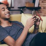 Junge h&ouml;rt Musik &uuml;ber Smartphone.