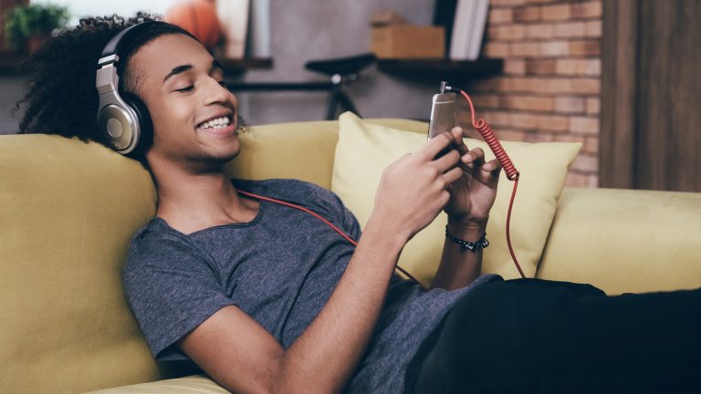 Junge h&ouml;rt Musik &uuml;ber Smartphone.