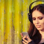 M&auml;dchen h&ouml;rt Musik &uuml;ber Smartphone.