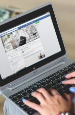 Userin surft auf einem Laptop durch Facebook