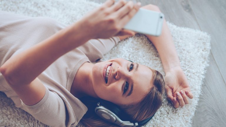 Frau mit iPhone nutzt Google Assitant