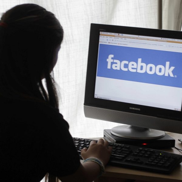 Eine Frau sitzt am Computer, auf dem Facebook l&auml;uft
