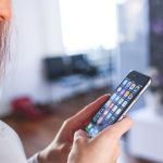 Frau mit iOS auf Smartphone