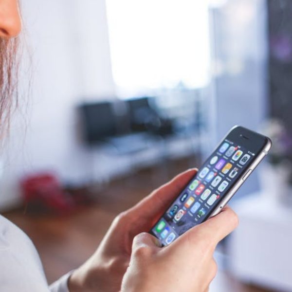 Frau mit iOS auf Smartphone