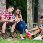 Gruppe mit Smartphones beim Camping