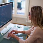 Frau sitzt am frisch eingerichteten iMac