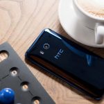 Das HTC U11 liegt mit dem Display auf dem Tisch zusammen mit einer Tasse Kafee