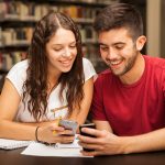 Paar mit Smartphones in Bibliothek