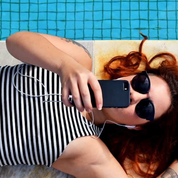 Junge Frau h&ouml;rt Musik &uuml;ber Smartphone