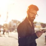 Mann mit Smartphone in der City