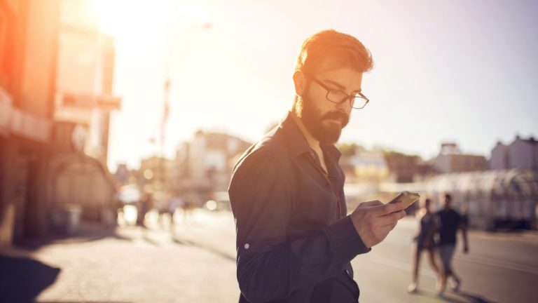 Mann mit Smartphone in der City