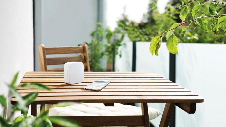 Elgato Eve Weather mit iPhone auf Gartentisch