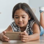 Kind schaut auf ein Smartphone