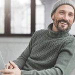Mann mit Laptop auf dem Sofa