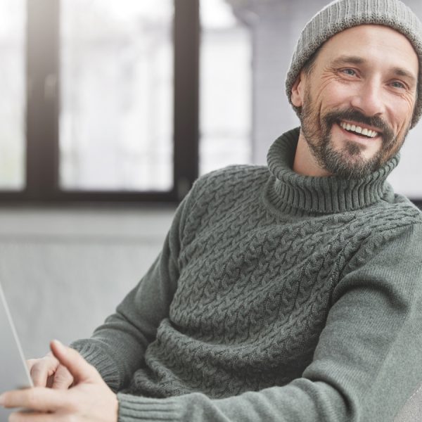 Mann mit Laptop auf dem Sofa