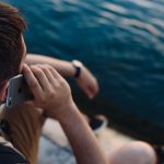 Mann telefoniert mit iPhone im Sommer