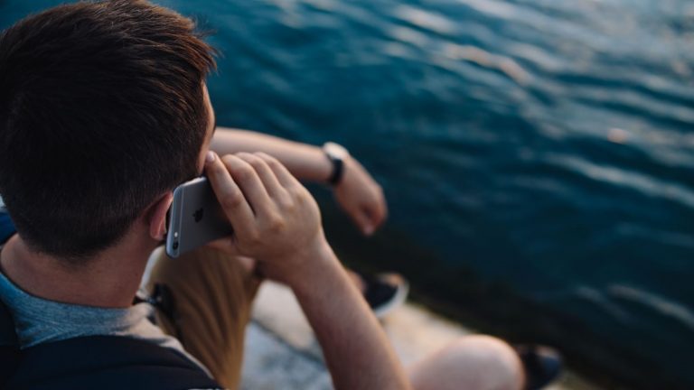 Mann telefoniert mit iPhone im Sommer