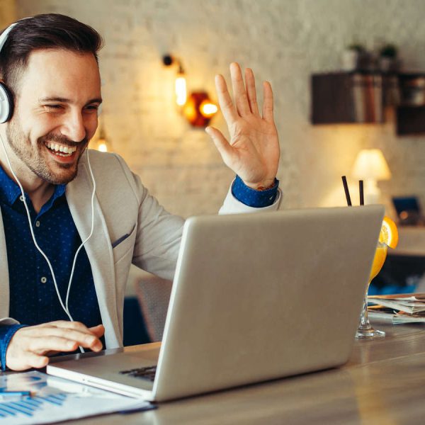 Mann nutzt Skype-Videochat am Laptop