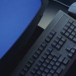 Sicht von oben auf einen R&ouml;hren-Monitor mit Tastatur und Maus auf dem Tisch