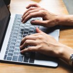 Mann tippt am Notebook