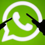 Smartphone-User vor WhatsApp-Logo