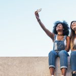 Zwei junge Frauen machen Selfie mit dem iPhone und wollen es per Mail-Anhang versenden