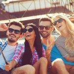 Eine Gruppe von 4 Menschen macht ein Selfie mit einem Selfiestick