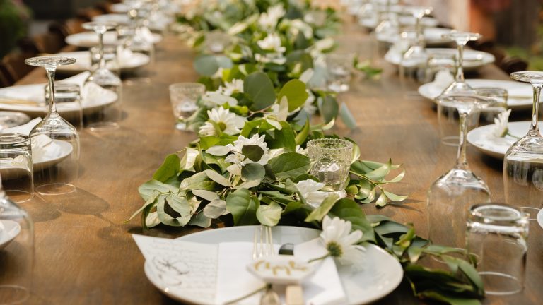 Lange Hochzeitstafel mit Gedeck und Blumen