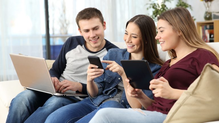 Drei Personen surfen auf dem Sofa im Internet Drei Personen surfen auf dem Sofa im Internet