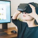 Frau mit VR Brille sitzt vor PC