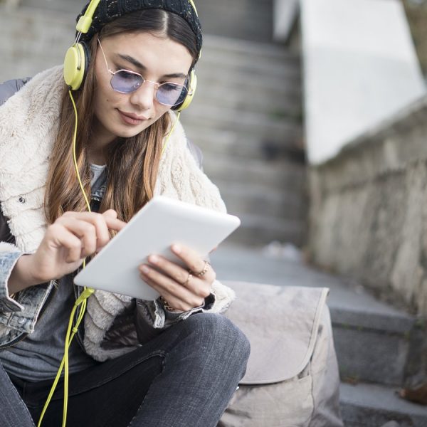 Junges M&auml;dchen erg&auml;nzt auf Tablet Songs f&uuml;r gemeinsame Spotify-Playlist