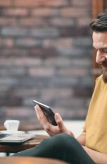 Google Authenticator: Backup erstellen und übertragen Junger Mann nutzt im Café den Google Authenticator auf mehreren Geräten