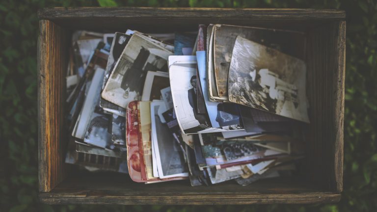 Alte Fotos liegen in einer Kiste und können mit Fotoscanner-Apps digitalisiert werden