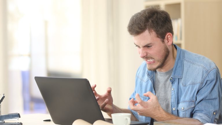 Word: Fußnoten leicht einfügen Mann ärgert sich vor dem Laptop