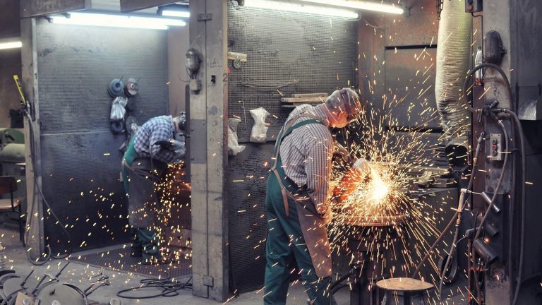Industriefotografie: M&auml;nner arbeiten mit Metall und lassen Funken spr&uuml;hen