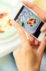 Instagram-Daten schützen Instagram-Daten schützen: Junge Frau fotografiert ihr Essen mit dem Smartphone