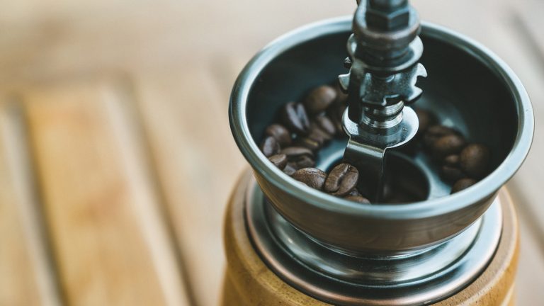 Kaffeemühle reinigen: Mahlwerk mit Reinigungspinsel und Staubsauger säubern
