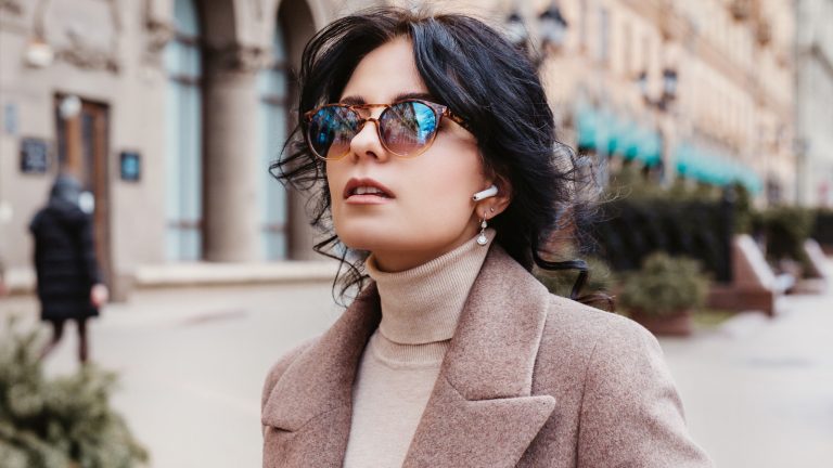 Frau auf der Stra&szlig;e mit AirPods im Ohr